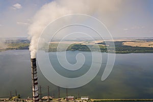 Aerial view of high chimney pipes with grey smoke from coal power plant. Production of electricity with fossil fuel