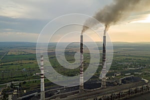 Aerial view of high chimney pipes with grey smoke from coal power plant. Production of electricity with fossil fuel