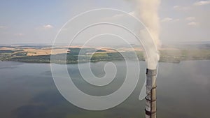 Aerial view of high chimney pipes with grey smoke from coal power plant. Production of electricity with fossil fuel.