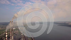 Aerial view of high chimney pipes with grey smoke from coal power plant. Production of electricity with fossil fuel