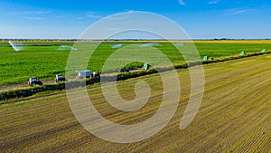 Aerial view on high pressure agricultural water sprinkler, sprayer, sending out jets of water to irrigate corn farm crops