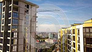 Aerial view of high residential apartment building with storey numbers on wall under construction. Real estate development.