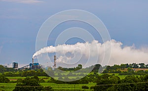 Aerial view of high smoke stack with smoke emission. Plant pipes pollute atmosphere. Industrial factory pollution, smokestack