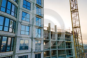 Aerial view of high tower crane and residential apartment buildings under construction. Real estate development