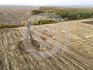 Aerial view of High-voltage power transmission towers over farm fields