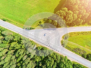 Aerial view of highway. Aerial view of a country road with moving car. Car passing by. Aerial road. Aerial view flying. Captured f