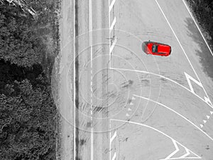 Aerial view of highway. Aerial view of a country road with moving red car. Car passing by. Aerial road. Aerial view flying. Captur