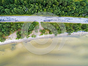 Aerial view of highway. Aerial view of a country road near the lake. Car passing by. Aerial road. Aerial view flying. Captured fro