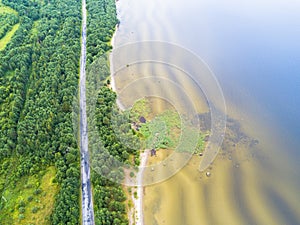 Aerial view of highway. Aerial view of a country road near the lake. Car passing by. Aerial road. Aerial view flying. Captured fro