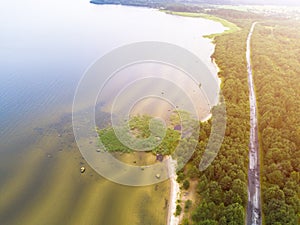 Aerial view of highway. Aerial view of a country road near the lake. Car passing by. Aerial road. Aerial view flying. Captured fro