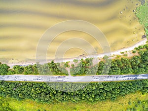 Aerial view of highway. Aerial view of a country road near the lake. Car passing by. Aerial road. Aerial view flying. Captured fro