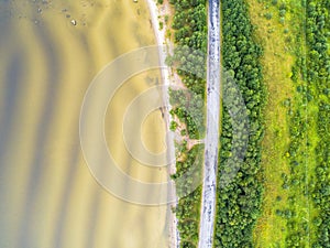 Aerial view of highway. Aerial view of a country road near the lake. Car passing by. Aerial road. Aerial view flying. Captured fro