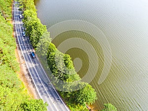 Aerial view of highway. Aerial view of a country road near the lake. Car passing by. Aerial road. Aerial view flying. Captured fro