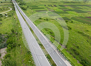 Aerial view of highway with car. Aerial view of a country road with moving car. Car passing by. Aerial road. Aerial view flying.