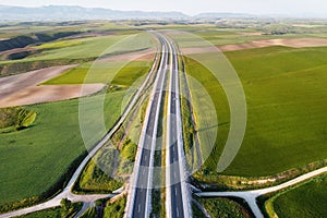 Aerial view of a highway with cars and trucks, in a beautiful countryside scenery.