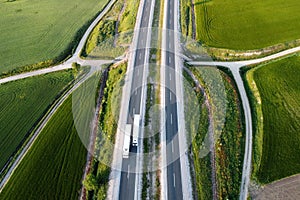 Aerial view of a highway with cars and trucks, in a beautiful countryside scenery.