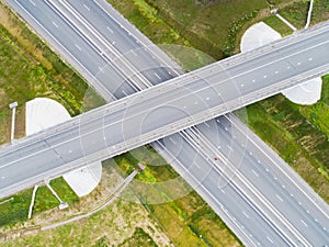 Aerial view of highway in city. Cars crossing interchange overpass. Highway interchange with traffic. Aerial bird`s eye photo of