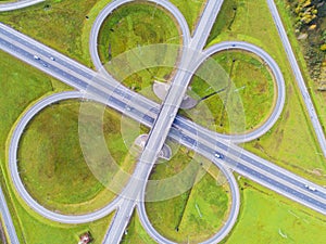 Aerial view of highway in city. Cars crossing interchange overpass. Highway interchange with traffic. Aerial bird`s eye photo of h