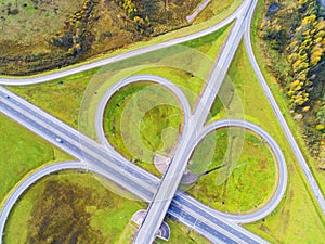 Aerial view of highway in city. Cars crossing interchange overpass. Highway interchange with traffic. Aerial bird`s eye photo of h