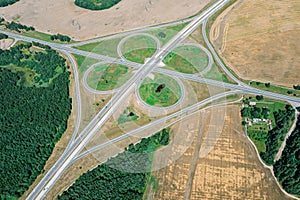 Aerial view of a highway intersection with a clover-leaf interchange in rural landscape
