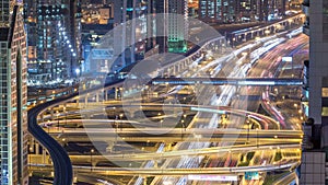 Aerial view of highway junction with traffic timelapse in Dubai, UAE, at night. Famous Sheikh Zayed road in Dubai