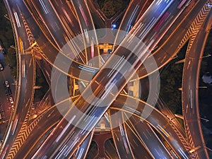 Aerial view of highway junctions shape letter x cross at night with fog. Bridges, roads, or streets in transportation concept.