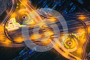 Aerial view of highway junctions Top view of Urban city, Bangkok at night, Thailand. Light trails across road junction, traffic