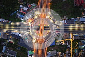 Aerial view of highway junctions Top view of Urban city, Bangkok at night, Thailand. Light trails across road junction, traffic