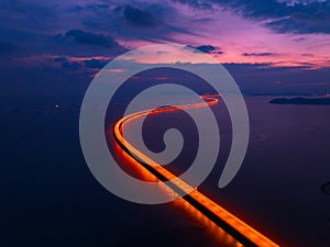 Aerial view of highway light of Penang Second Bridge with dramatic twilight sunset colorful sky background