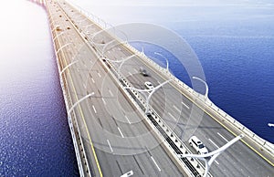 Aerial view of highway in the ocean. Cars crossing bridge interchange overpass. Highway interchange with traffic. Aerial bird`s ey