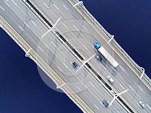 Aerial view of highway in the ocean. Cars crossing bridge interchange overpass. Highway interchange with traffic. Aerial bird`s e