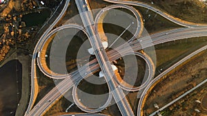 Aerial view. Highway and overpass with cars and trucks. The road junction is a two-tier road junction outside the city