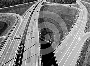 Aerial view of highway and overpass in city. Aerial view of cars crossing interchange overpass. Highway interchange with traffic.