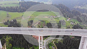 Aerial view of the Highway Viaduct on Concrete Pillars with Traffic in Mountains