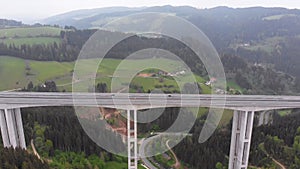 Aerial view of the Highway Viaduct on Concrete Pillars with Traffic in Mountains