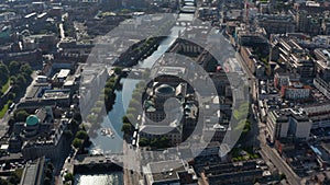 Aerial view of historic buildings with domes on riverbanks. Traffic on bridges across Liffey river. Dublin, Ireland