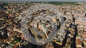 Aerial view of historic tourist sights in city centre. Towers and domes of churches and basilicas, buildings lit by