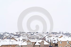 Aerial view of homes with snowy roofs against cloudy sky in a winter landscape