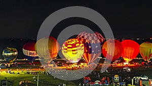 Aerial View of Hot Air Balloons Doing a Balloon Glow at Night on a Summer Evening