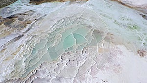 Aerial view of hot springs with blue water white baths. Travertines of Pamukkale in Turkey