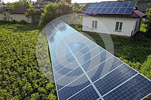 Aerial view of a house with blue solar panels for clean energy