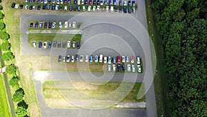 Aerial view of a huge car parking lot panning from the single car to many