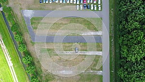 Aerial view of a huge car parking lot panning from the single car to many and back - time lapse