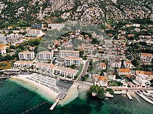 Aerial view of Huma Kotor Bay Hotel and Villas on the seashore at the foot of the mountains. Dobrota, Montenegro