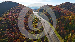 Aerial view of I-40 freeway in North Carolina heading to Asheville through Appalachian mountains in golden fall with