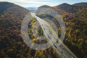 Aerial view of I-40 freeway in North Carolina heading to Asheville through Appalachian mountains in golden fall with