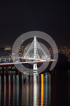 Aerial view of the iconic San Francisco-Oakland Bay Bridge at night, illuminated by city lights