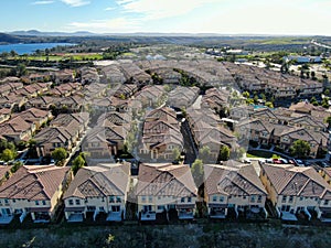 Aerial view of identical residential subdivision condo with big lake and mountain on the background during sunny day