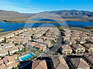 Aerial view of identical residential subdivision condo with big lake and mountain on the background during sunny day