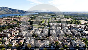 Aerial view of identical residential subdivision house with big lake and mountain on the background